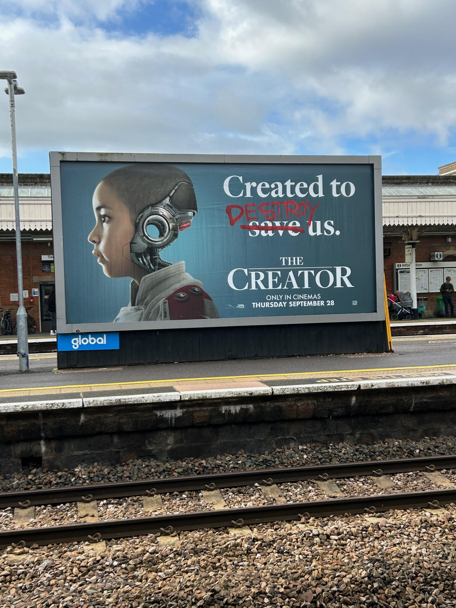 Image of film poster with an image of a human face with a robotic head and text that reads "created to save us" but the word save is crossed out in blood and replaced with "destroy".