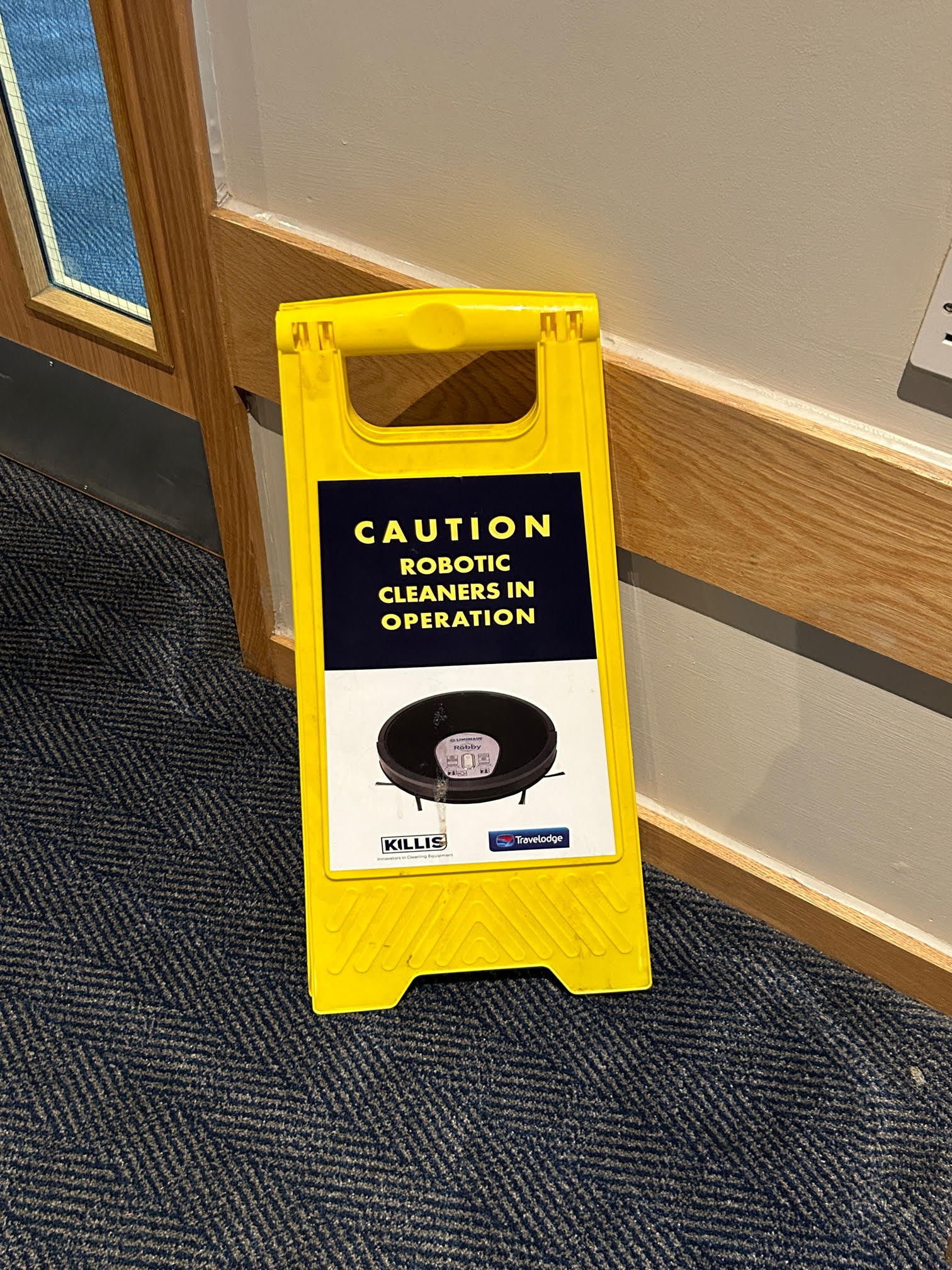 Image of yellow floor sign that reads "caution robotoic cleaners in operation".
